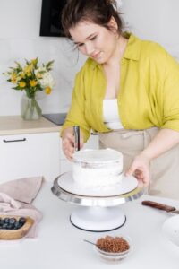 woman preparing delicious cake in kitchen